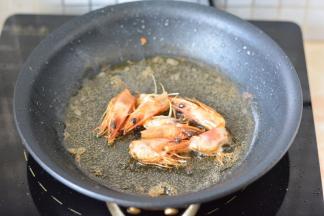 锅里放油烧热，把虾头放进去，煸炒出香味，放入虾炒至变色，关火备用