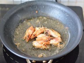 锅里放油烧热，把虾头放进去，煸炒出香味，放入虾炒至变色，关火备用