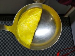 用勺子或筷子轻轻挑起蛋皮一边对折，压在等边上凝固住即可