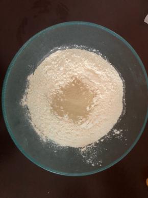 称好面粉，倒入发酵粉，先用筷子搅拌均匀。