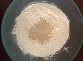 称好面粉，倒入发酵粉，先用筷子搅拌均匀。