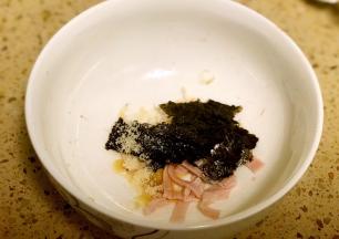 碗底放入调料2及虾皮、紫菜和一半的火腿丝。
