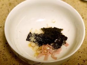 碗底放入调料2及虾皮、紫菜和一半的火腿丝。