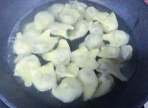 锅内水烧热后下入馄饨煮熟。