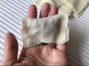 取一个皮，放入馅料，如图捏严。