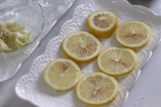 柠檬片平铺到用来蒸制的盘子上。