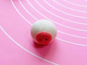 取一个包好的汤圆，把猪鼻子沾在汤圆上。(可以涂一点水沾猪鼻子)