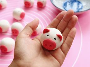 把猪耳朵用牙签装上，再用黑芝麻装上眼睛。(沾一点水在装眼睛)