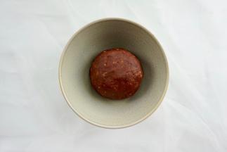 把核桃碎倒入红豆沙中，揉成团。然后平均分成7个小球备用。