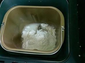 把（油皮）的所有食材放入面包机，启动揉面程序，揉成面团；也可以用手揉，揉至猪油完全吸收即可。
