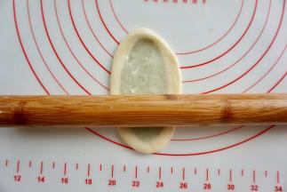 取一个面团，擀成牛舌状；