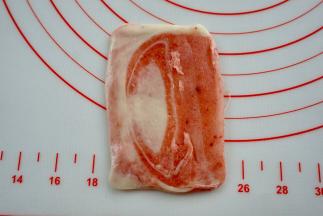 取出一个红色面卷，收口上向上。擀成一个小长方形面片