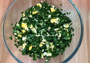 加入玉米油轻轻翻拌均匀，千万不可以过度搅拌，让每片韭菜都被油裹住，这样韭菜才不会出太多的汤汁， 然后把晾凉的鸡蛋倒入韭菜中，加入适量的盐轻轻翻拌均匀即可，盐一定要开始包的时候再加入，先加盐会让韭菜出汁的，这一点一定要注意