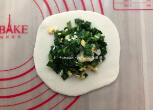 取一个小剂子擀成大圆饼皮，码上韭菜鸡蛋馅