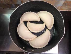 平底锅加热放少量油，油微微加热，然后依次把韭菜盒子摆放在锅中