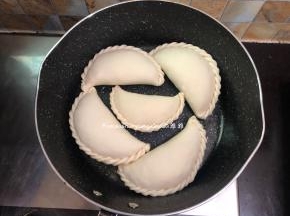 平底锅加热放少量油，油微微加热，然后依次把韭菜盒子摆放在锅中