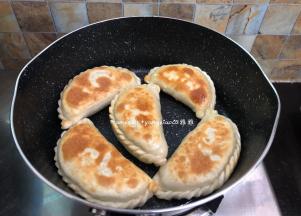 底部煎至金黄色就把韭菜盒子翻个面翻面继续煎，两面都煎至金黄色即可出锅