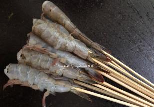 然后用竹签把虾多虾的尾部开始，把虾逐一串好