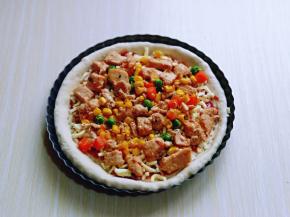 再把做好的奥尔良鸡肉均匀的铺在披萨皮上面。