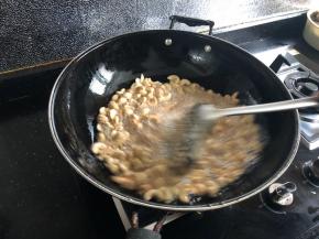 用漏勺不停地搅拌，让所有的腰果受热均匀。