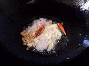 放入毛葱、生姜、大蒜、红辣椒爆香