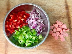 红椒、青椒、洋葱洗净，切小丁，火腿肠切片。
