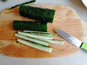 黄瓜洗干净，一般我会先用盐擦一次黄瓜皮，再用饮用水冲洗几遍，切薄片备用