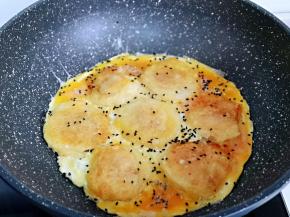 蛋液凝固后，撒上熟黑芝麻，即可关火。