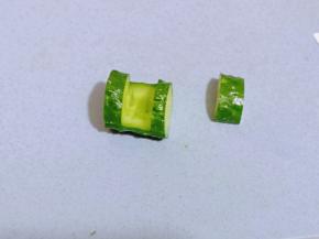 之后开始做黄瓜盅，在黄瓜的两边切出约1厘米左右深度的薄片，再一段黄瓜的两边，轻轻的划开，不要切到底部，之后再沿着此开口横切，将上面这块黄瓜拿掉。