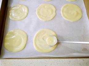 用勺子挖一点面糊倒在烤盘里，勺子的底部转圈摊成小圆饼。