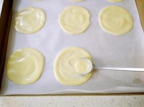 用勺子挖一点面糊倒在烤盘里，勺子的底部转圈摊成小圆饼。