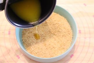 黄油隔热水融化成液体，倒入消化饼干内。