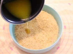 黄油隔热水融化成液体，倒入消化饼干内。