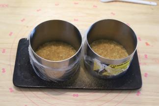 把饼干末倒入慕斯圈内，擀面杖压实，冰箱冷藏备用。