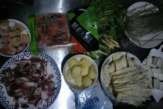 准备食材，羊肉切薄片，小土豆去皮洗净，藕去皮洗净切薄片，金针菇洗净撕小朵，豆腐切块，茼蒿洗净，备用
