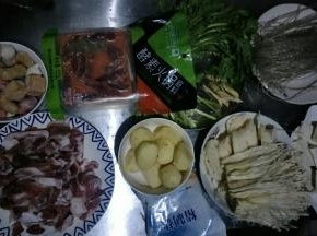 准备食材，羊肉切薄片，小土豆去皮洗净，藕去皮洗净切薄片，金针菇洗净撕小朵，豆腐切块，茼蒿洗净，备用