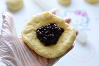 把面团擀成圆形，包入紫米饭，底部收口揉圆