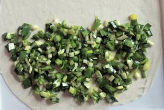 把适量韭菜馅摊在一半薄饼上