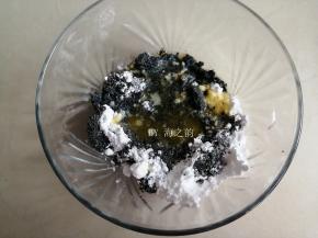 把糖粉和提前隔水融化的黄油倒入黑芝麻粉末里