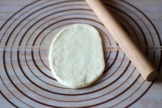 将面团擀成牛舌状，然后卷起