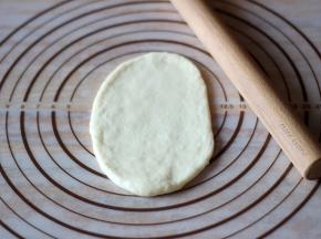 将面团擀成牛舌状，然后卷起