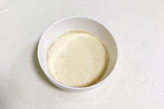 往牛奶中加入酵母粉，用筷子拌匀。