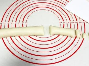 把面团搓成长条状，分成110克（小猪）、65克（橘子）、3克（小猪鼻子和耳朵）和2个1克（橘子的叶子和蒂）的面团。