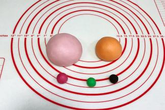 面团分别加入各颜色色素揉匀，110克加少许粉色色素，3克面团加入粉色色素（要比110克粉色面团深些），65克面团加入橙色色素，1克加入绿色色素，另一个1克加入可可粉或竹炭粉。