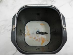 把鸡蛋和牛奶倒入面包桶中