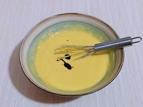 滴入红丝绒液，用手动打蛋器拌均匀，拌的时候使用手动打蛋器呈Z字形状来回搅动，不要转圈搅拌，以免起筋。这样蛋黄糊就做好了，放在旁边备用。