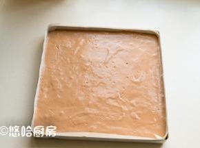 拌匀的面糊倒回余下的蛋白霜中继续翻拌均匀，倒入已铺好油布的烤盘中，烤盘在台面上轻震几下，震出面糊中的大气泡。