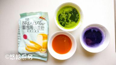 洗净的菠菜加少许的水，用料理机打碎，用纱布过滤掉残渣，保留汁水；胡萝卜和紫甘蓝洗净后切小块，加入少许的水用料理机打碎，同样用纱布过滤掉残渣保留汁水。三种颜色的蔬菜汁分装到三个碗中，同时准备压面条用的面粉。面包粉？没错，这次就是要用高筋面包粉。