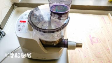 水杯中加入紫甘蓝的汁，水杯安装到位，按一下启动，面条机自动运转，待会就等着出面条了。