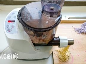紫色面条压好后，面条机自动停止，再次重复上面的步骤，蔬菜汁换成了胡萝卜汁，很快就出来黄色面条。